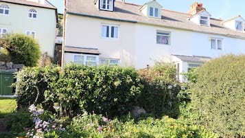 A row of houses with a garden in front.