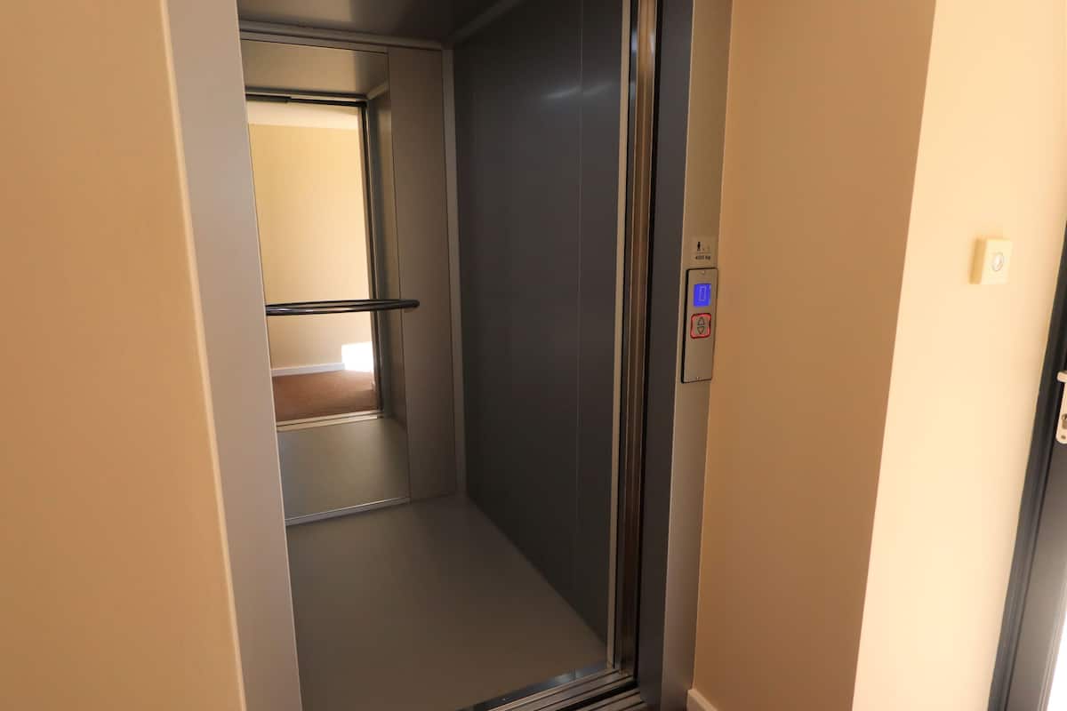 An elevator with a control panel displaying a digital display and a button.