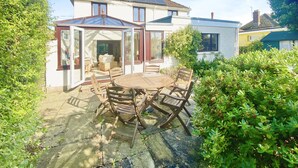 Una casa con un patio, una mesa de comedor y sillas.