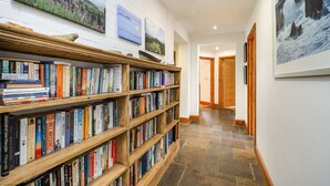 A library with bookshelves, a fireplace, and artwork on the walls. - The Old Signal House (Ventnor)