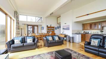 A spacious living room with a large window, a fireplace, and a dining area.