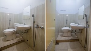 Une salle de bain avec des toilettes, un lavabo et une douche.