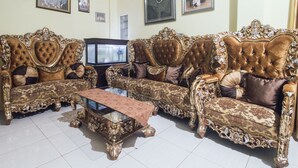 Un salon luxueux, agrémenté de canapés richement décorés et d’une table basse en verre.