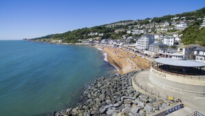 Une ville côtière avec une plage, des maisons et un grand bâtiment portant l’inscription « VENTNOR ».