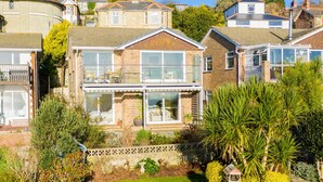 Il s’agit d’une propriété résidentielle dotée d’un grand jardin, d’une véranda et d’une maison à deux étages avec un balcon.