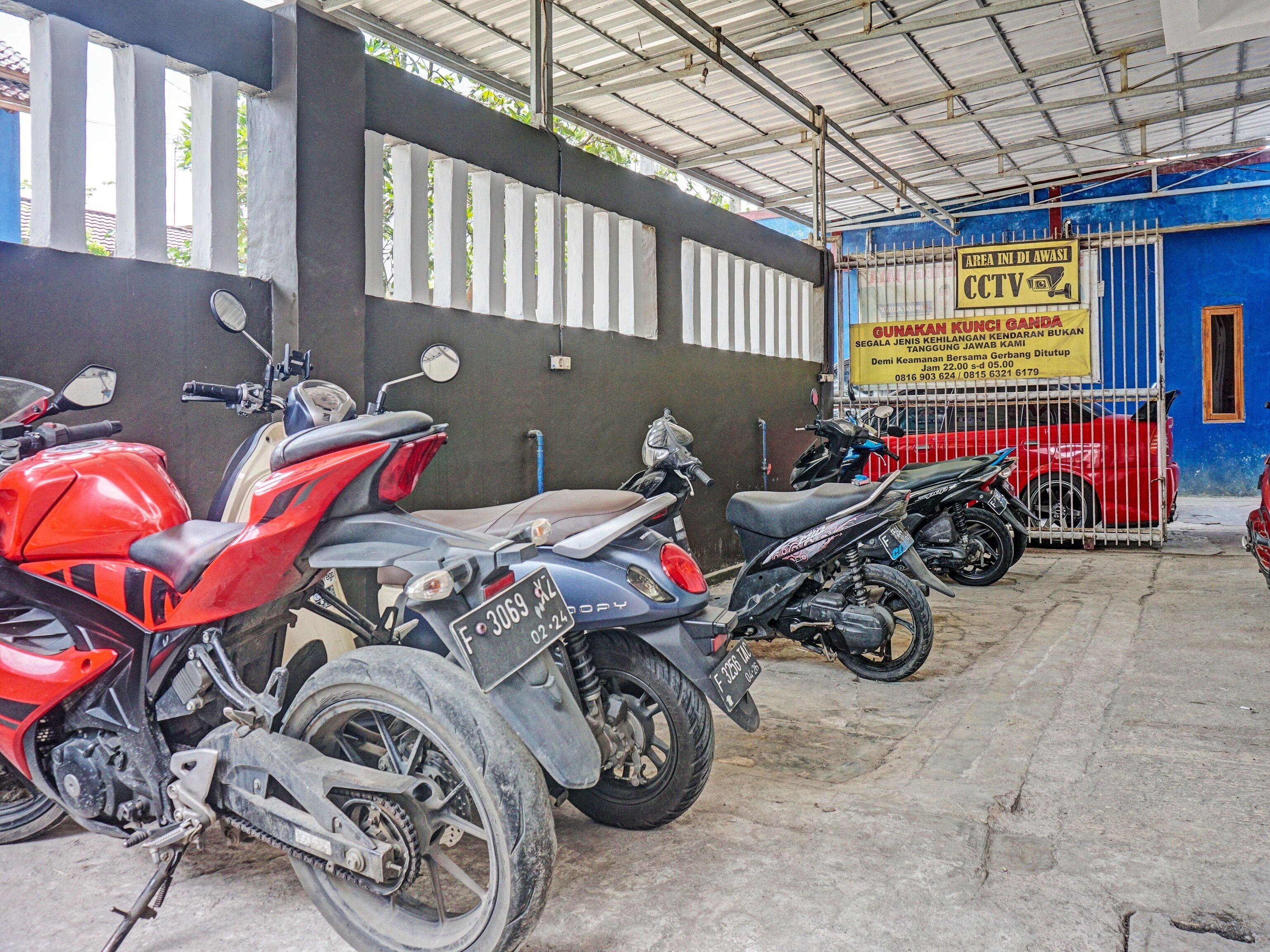 Varias motocicletas estacionadas dentro de un edificio con un letrero azul y blanco.