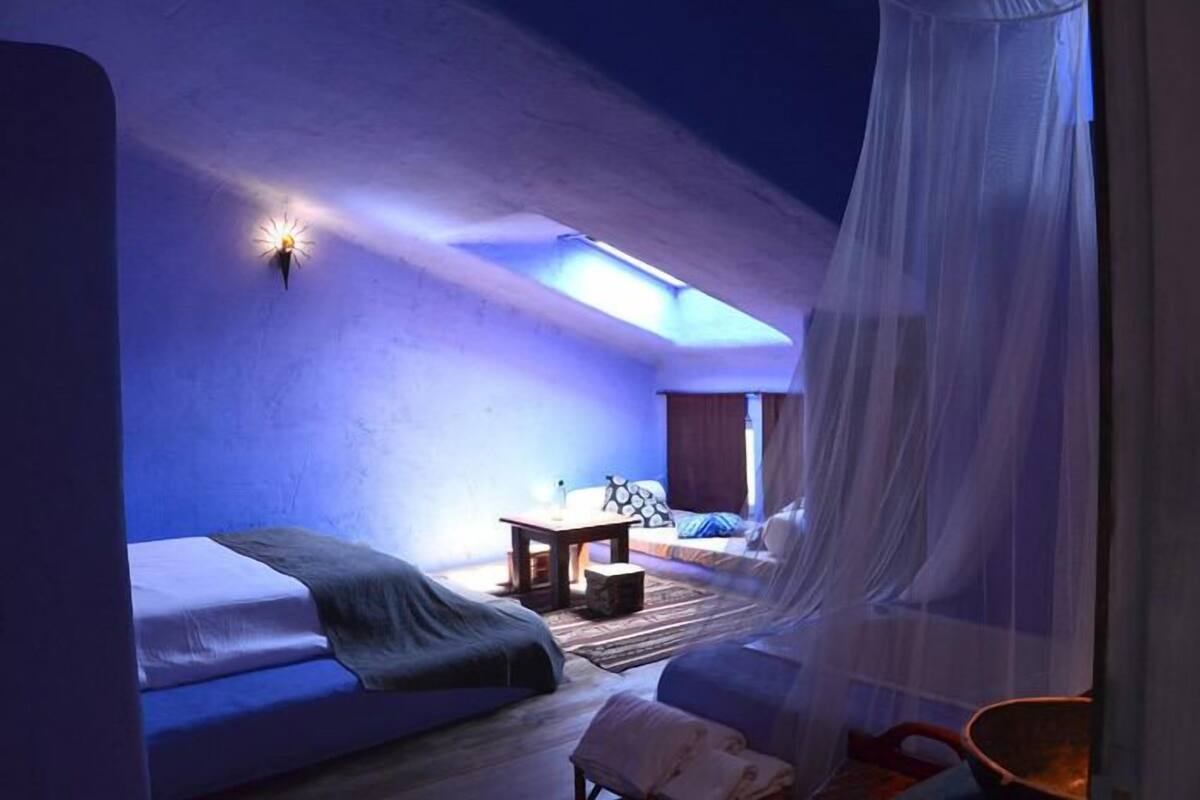 A room with a bed, a small table, and a chair.