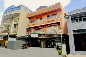 A multi-story building with balconies and a covered entrance. - OYO 2301 Hocky Guest House (Banjarmasin)