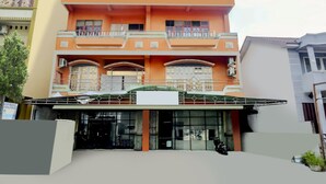 A multi-story building with a flat roof, large windows, and a covered entrance area. - OYO 2301 Hocky Guest House (Banjarmasin)