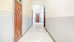 A hallway with patterned doors and tiled flooring. - OYO 2301 Hocky Guest House (Banjarmasin)