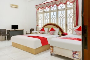 A hotel room with two beds, a desk with a computer, and a chair. - OYO 2301 Hocky Guest House (Banjarmasin)