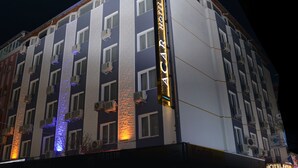 A multi-story hotel with a prominent sign reading "HOTEL AGAR". It features multiple air conditioning units attached to the exterior walls, a textured facade, and a series of windows.