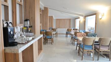 Un comedor moderno con paneles de madera, suelo de mármol y una combinación de sillas tapizadas y de madera.