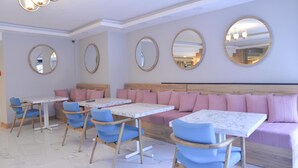 A modern dining area with round mirrors, wooden headboards, and blue chairs.
