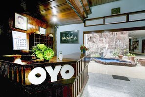 A reception desk with a calendar, framed pictures, and a small indoor garden.