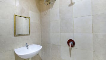 A bathroom with a white sink, a mirror, and a shower with a red handle.