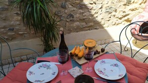 Uma mesa posta para dois, com pratos, talheres, uma garrafa e comida.