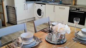 Une cuisine moderne équipée d’un lave-linge, d’un four à micro-ondes et d’un four traditionnel.