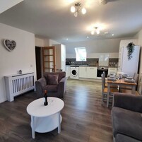 A modern apartment with a living room, dining area, and kitchen.