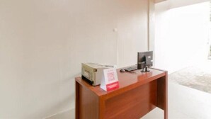 A reception desk with a printer, a computer, and a sign on the wall. - OYO 2228 Arwinda Costel (Cianjur)