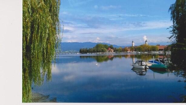 A calm lake with boats, a church, and a bridge in the background. - Cozy, homely apartment (Lindau-Bodolz)
