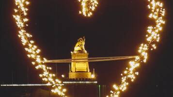 Un jeu de lumière en forme de cœur dans le ciel nocturne, avec un bâtiment en arrière-plan.
