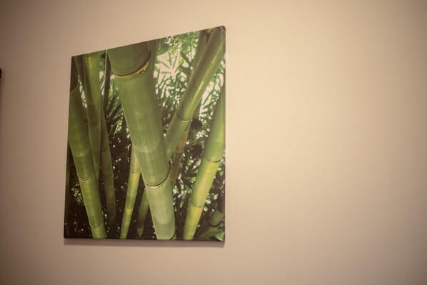 Une œuvre d’art encadrée représentant des tiges de bambou, accrochée à un mur.