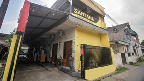 A two-story building with a yellow facade and a black roof. The sign above the entrance reads "SANTANA SYARIAH GUEST HOUSE." - Capital O 2258 Santana Syariah Guest House (Surakarta)