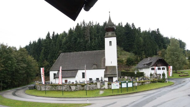 A white building with a tall tower, surrounded by greenery and a winding road. - Apartment in Krispl Near Ski Slopes (Krispl)