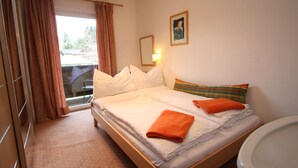 A hotel room with a bed, a bathroom, and a window with curtains. - Apartment in Krispl Near Ski Slopes (Krispl)
