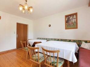 A dining area with wooden chairs and tables, a wooden bench, a chandelier, and a framed picture on the wall. - Sunlit Farmhouse near Hochzillertal Ski Area in Tyrol (Hart im Zillertal)