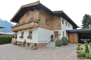 Un bâtiment à deux étages doté d’un balcon, d’un escalier menant à l’entrée et d’un garage.