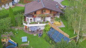 A two-story house with a balcony, a play area, and solar panels. - Animal -friendly Apartment in Leogang (Leogang)