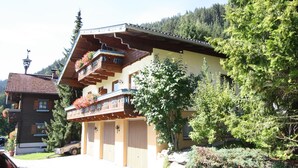 A traditional chalet with a wooden facade, a balcony with flower boxes, and a mountain backdrop. - Simplistic Apartment in Kleinar near Cross Country Skiing (Kleinarl)