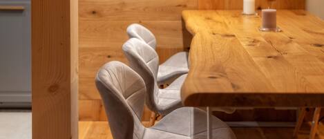 Una mesa de comedor de madera con una vela y una silla de diseño único.