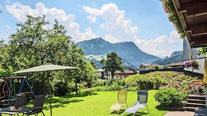 A patio with a swing set, two lawn chairs, and a table. - Vintage Apartment in Fügen near Ski Area (Fuegen)