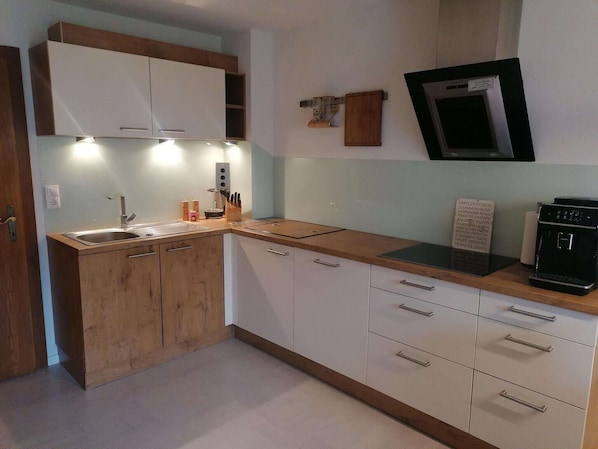 Apartment | Private kitchen | Stovetop, electric kettle, highchair, cookware/dishes/utensils