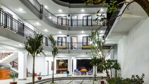 A multi-level courtyard with stone flooring, potted plants, and a staircase leading to the upper floors. - Elizabeth Hotel Tam Coc (Nam Hoa Lu)