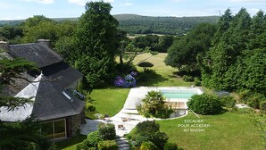 A house with a swimming pool, a staircase leading to the pool, and a view of the surrounding landscape. - Country house Quevarec (Dinéault)
