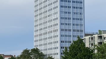 Ein hohes, modernes Gebäude mit einer gitterförmigen Fassade und vielen Fenstern.
