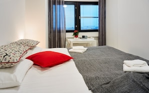 Relax in a stylishly designed room with a large bed, bedside table, and a potted plant.