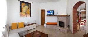 Smart TV, caminetto, libri, impianto stereo