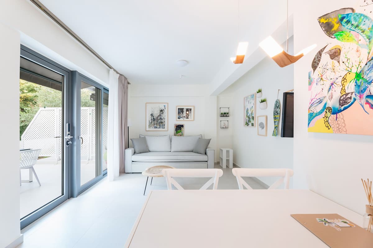 Departamento Deluxe, 2 habitaciones | Área de sala de estar | Smart TV de 38 pulgadas con canales por cable y televisión