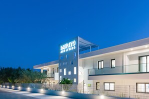 Vista frontal de la propiedad por la tarde o noche