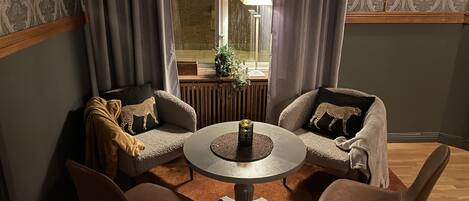 Ein gemütliches Zimmer mit zwei Sofas, einem runden Tisch und zwei Stühlen.
