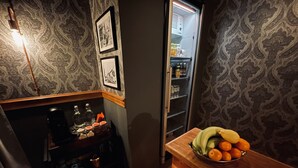 A kitchen area with a refrigerator, a wooden counter with a bowl of fruit, and a coffee machine. - Agardhs Pensionat (Sveg)
