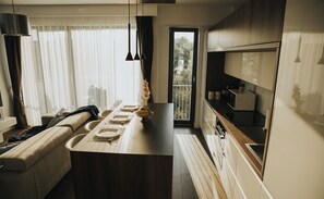 Enjoy meals in the kitchen with a central island, sink, and microwave, and dine in the adjacent seating area with a sofa and dining table for four.