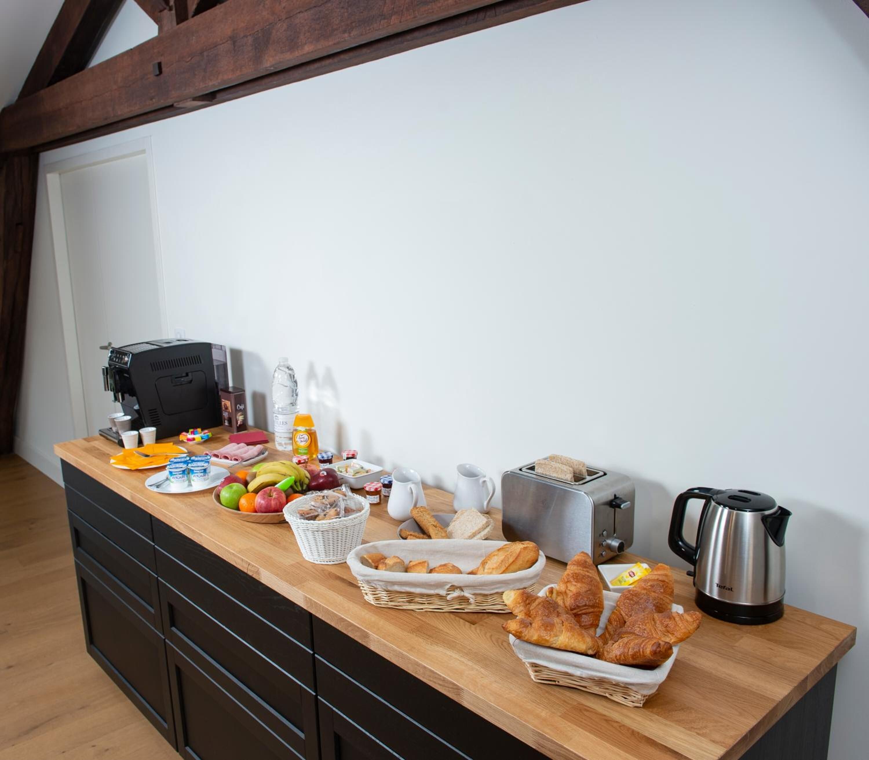 Un buffet de desayuno con diversos alimentos, una máquina de café y un tostador.