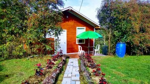 Ein Holzhaus mit einem gepflasterten Weg, der zu einer weißen Tür führt.
