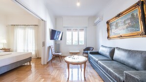 Una sala de estar moderna con un sofá, una mesa de centro, un televisor y un cuadro en la pared.